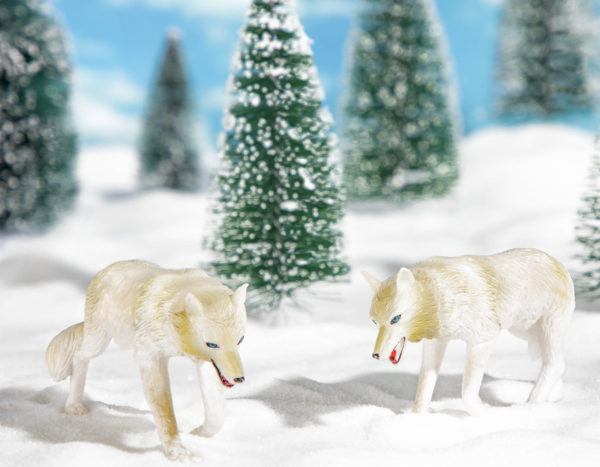 Two toy wolf figurines in snow