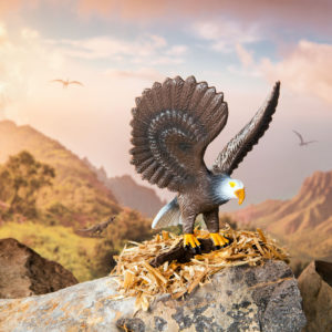 Toy bald eagle figurine on rocks