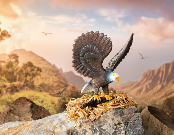 Toy bald eagle figurine on rocks