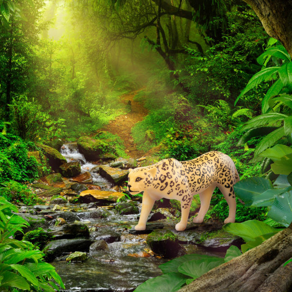 Toy jaguar figurine in jungle