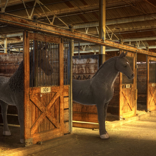 Toy Friesian horse figurines in stable