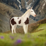 Toy Spotted Saddle horse figurine in mountains