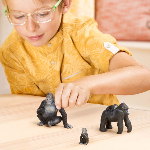Kid playing with toy gorilla figurines