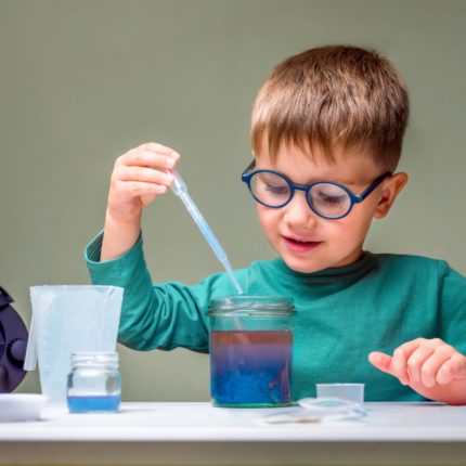 Young boy with jar and water dropper