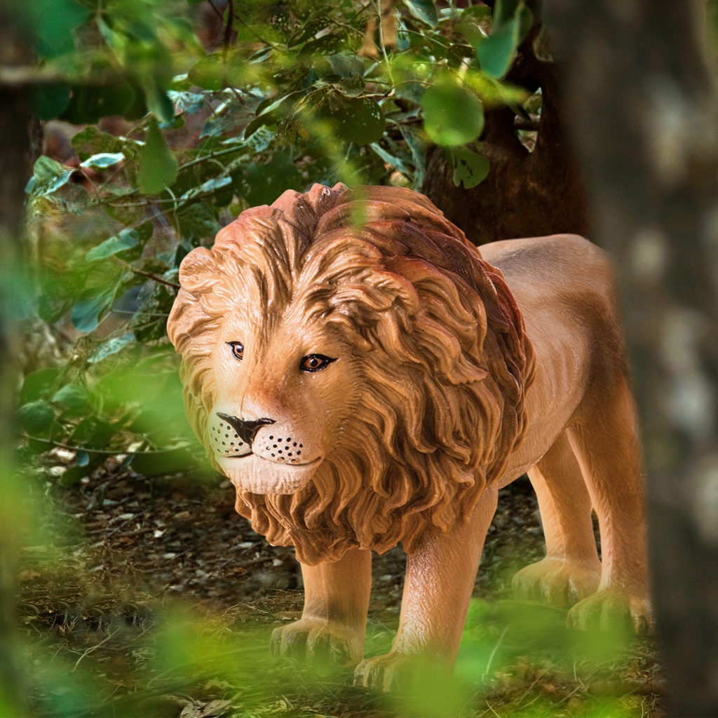 toy lion in a jungle