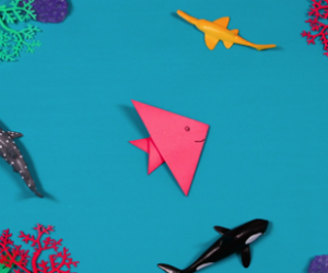 pink paper fish on blue background.