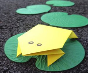 yellow paper frog on green lily pad.