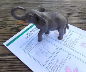 toy elephant on desk with sheet of paper.