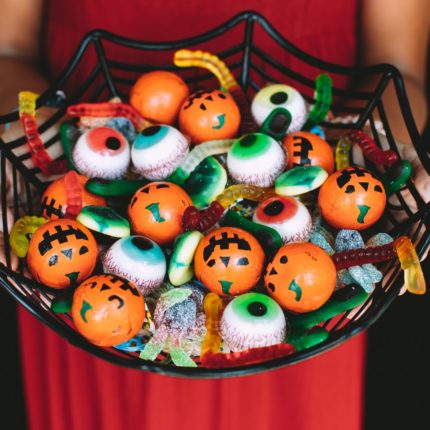 A cobweb shaped bowl holds a selection of Halloween candy.