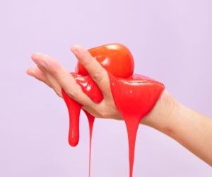 A hand holding orange slime.